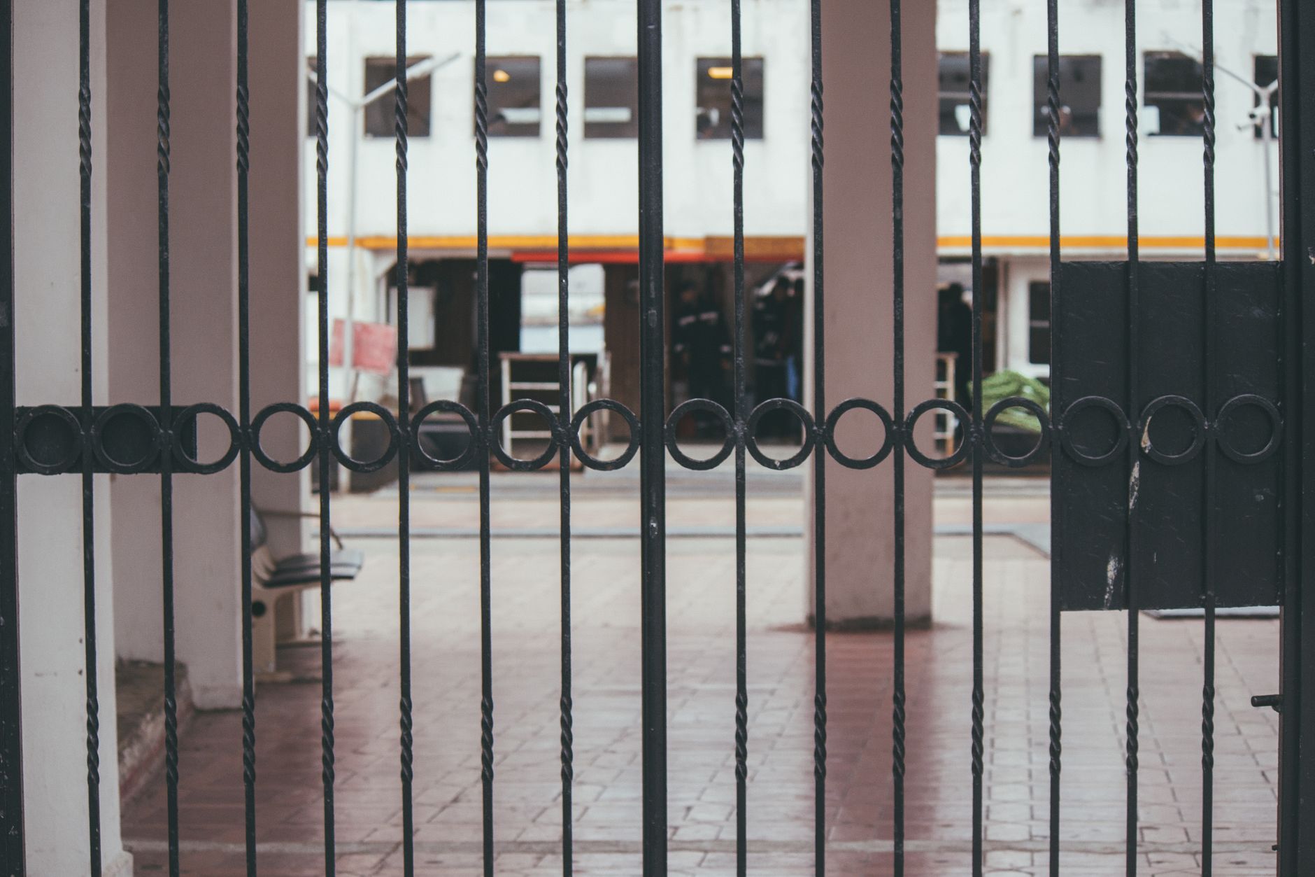 A modern iron gate showcasing minimalist architecture with an urban backdrop in Pearland, TX